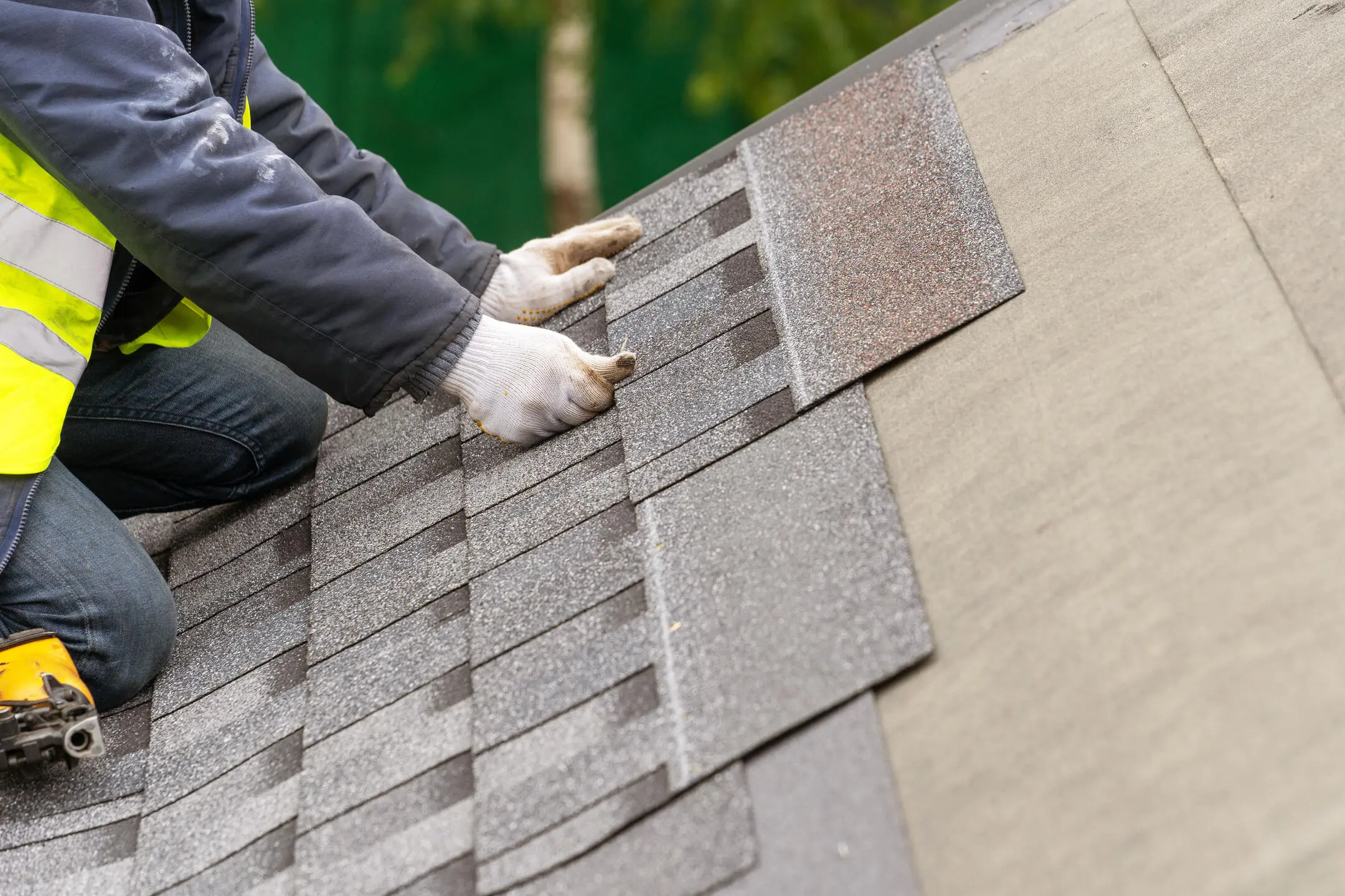 roof installation-close up of roofer installing new shingles on a roof