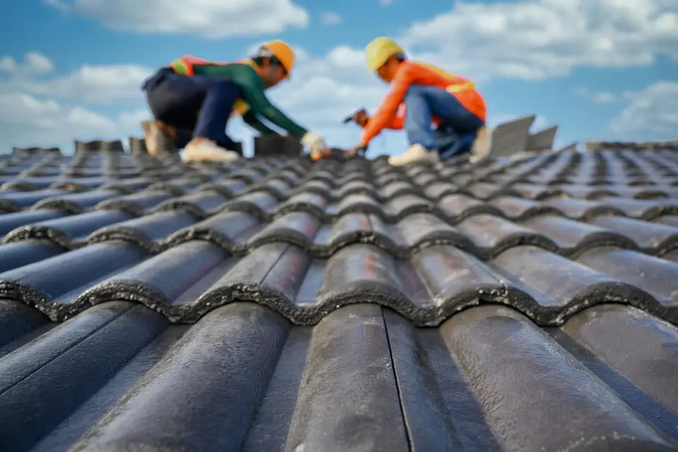 ceramic roof tiles-low angled view of roofers installing tile roofing