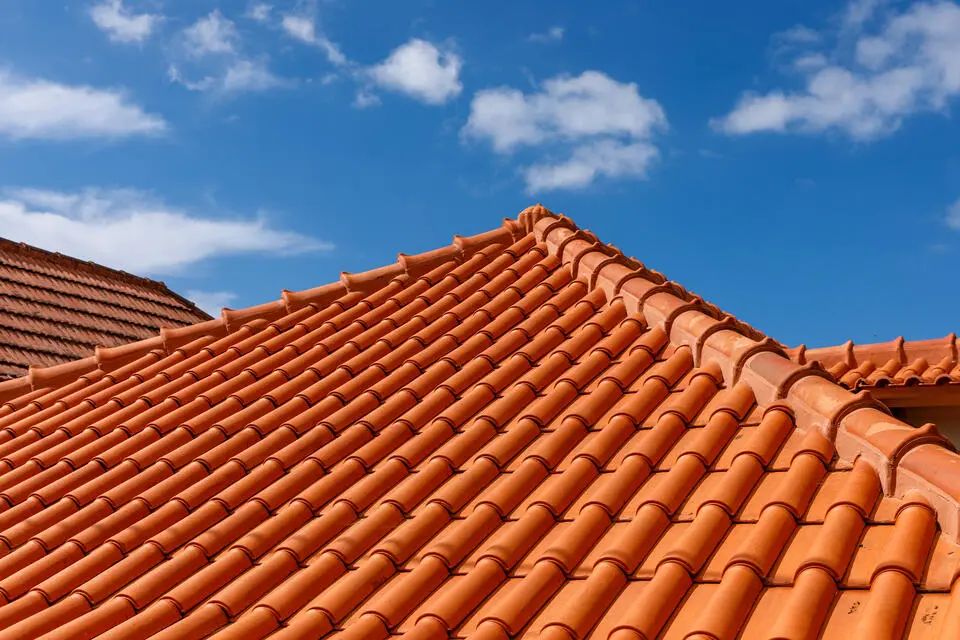 metal roof vs tile roof-peak of house with terracotta tile roofing