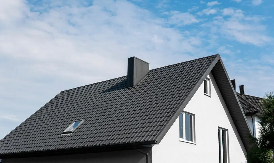 energy efficient roofing-black metal shingles on white sided house