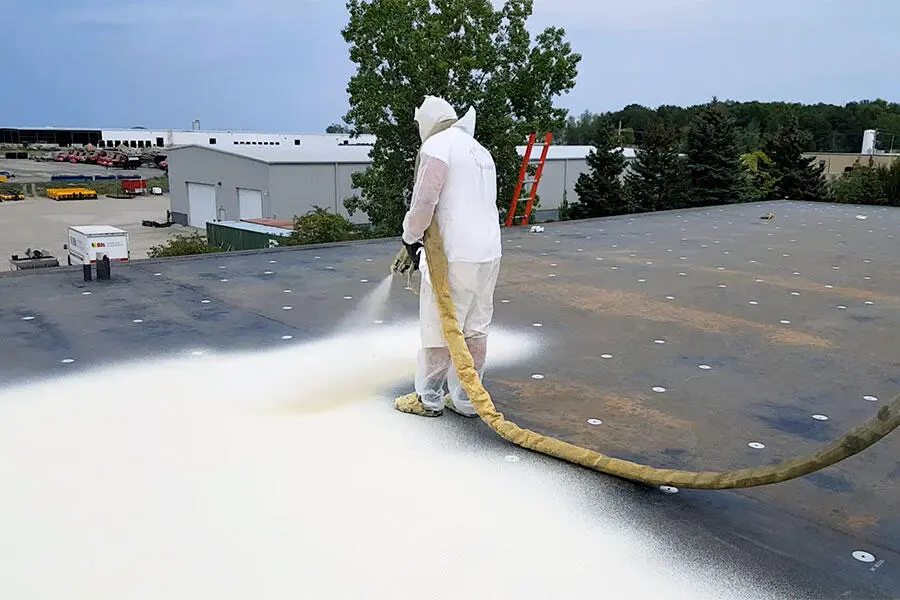 spray foam roofing-installation by a man in protective gear