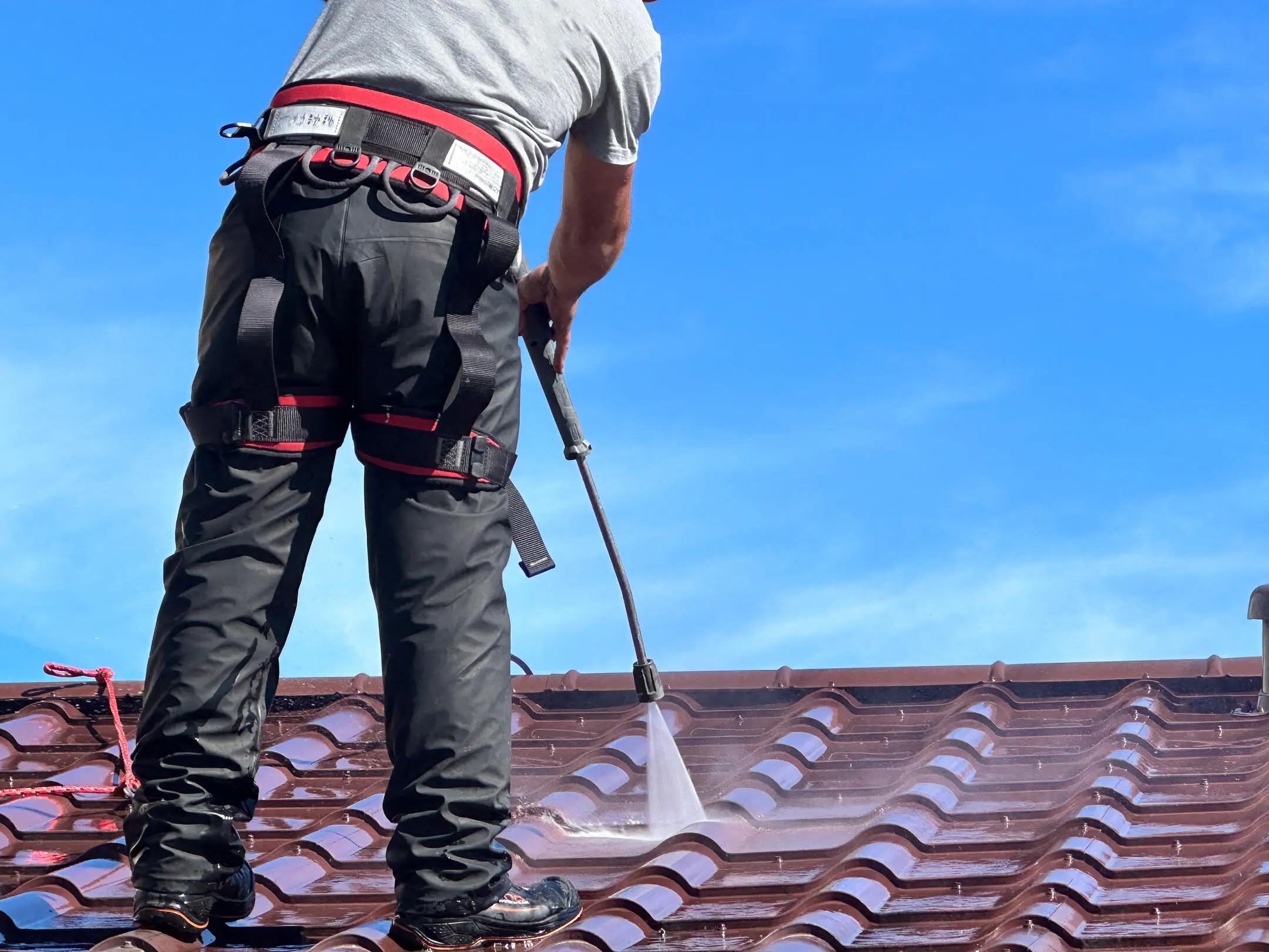how much to pressure wash a 2,000 sq ft house-close up image of a man pressure washing red roofing materials