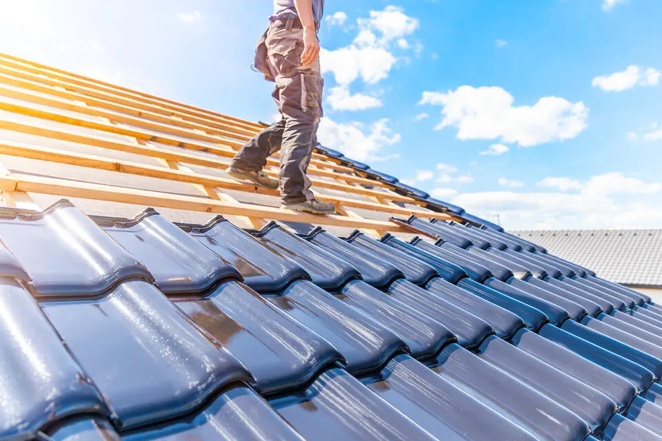 ceramic roof tiles-roofer standing on roof as he installs ceramic tiles