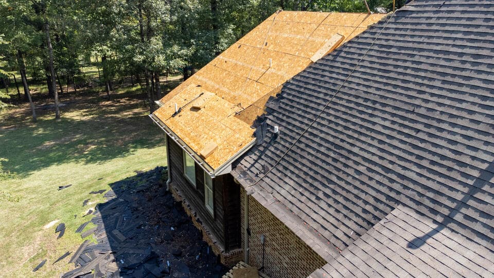roof installation-residential home with half the roof replaced and half exposed