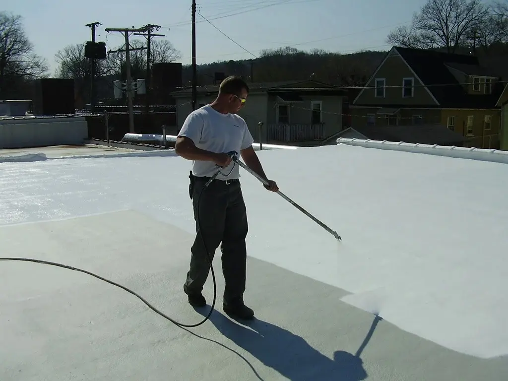 spray foaming roof-man spraying roofing material onto commercial flat roof