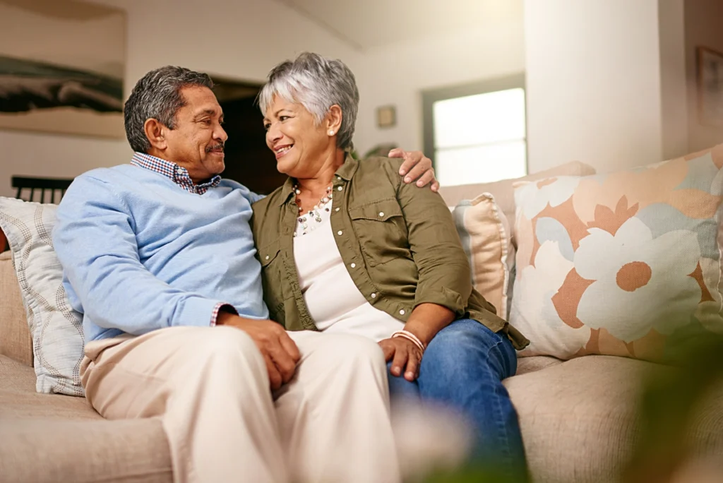 older couple on couch in florida home laughing and hugging