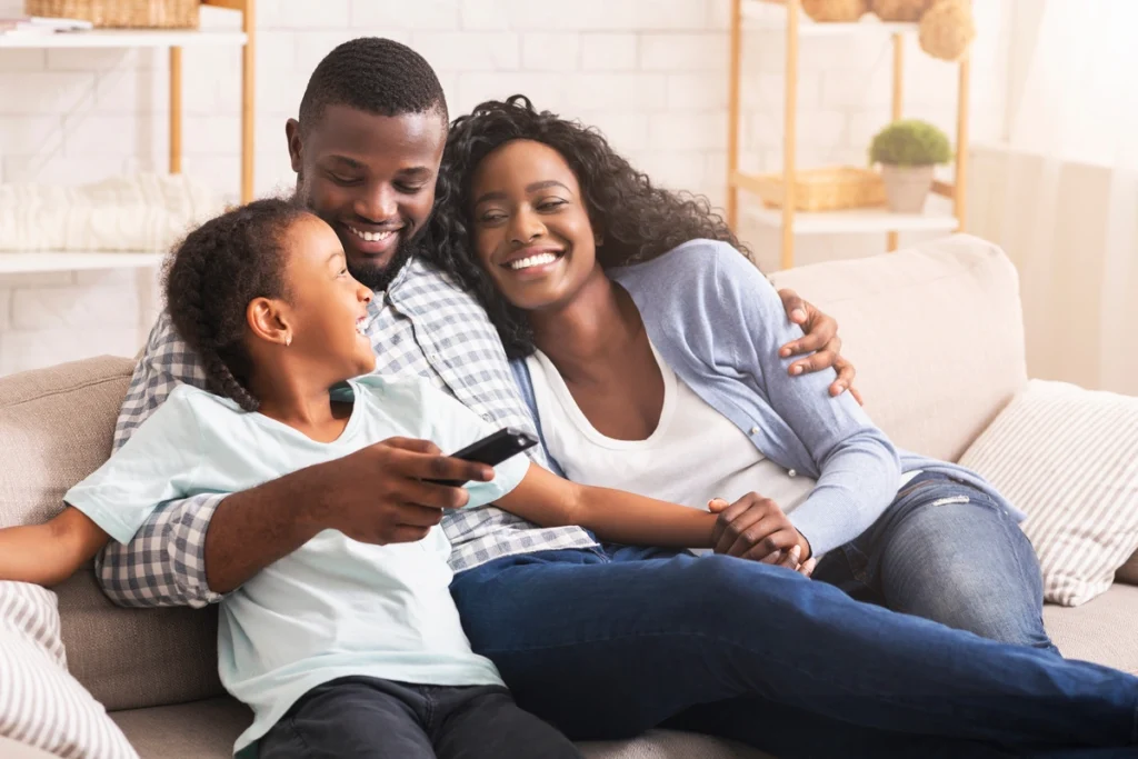 happy family of three sitting on the couch at home