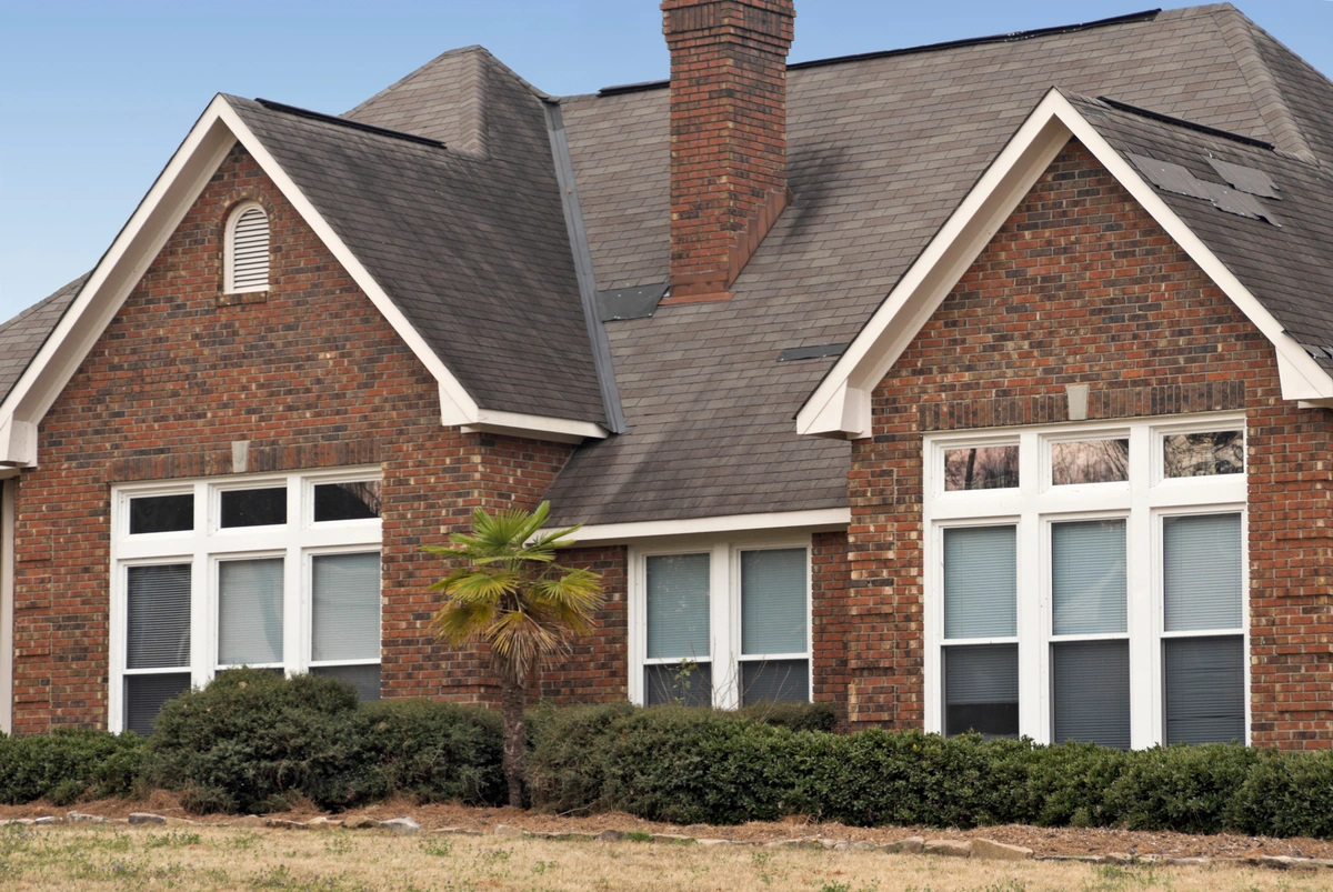 brick house with patches on the roof