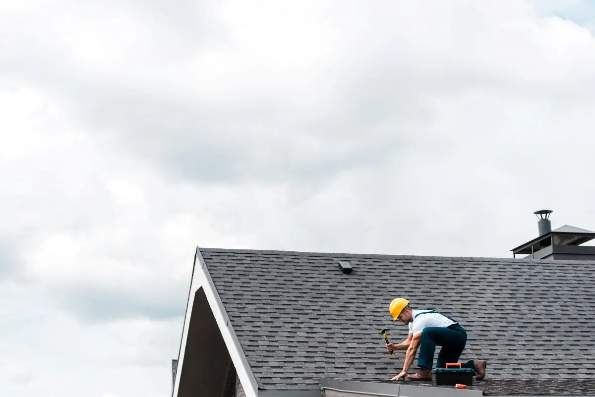 A gutter repair technician on a Minneapolis home — most repairs address fasteners, pitch, joints, or fascia connections