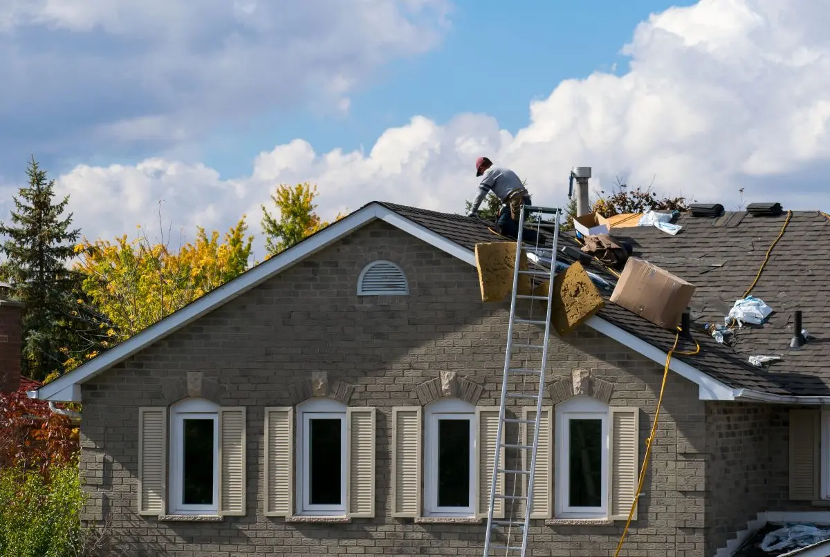 A crew of roofers repairing a roof on a house in Woodbury