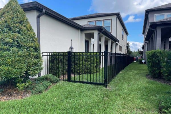 Black aluminum ornamental safety fence installation around a residential backyard and patio in Tampa