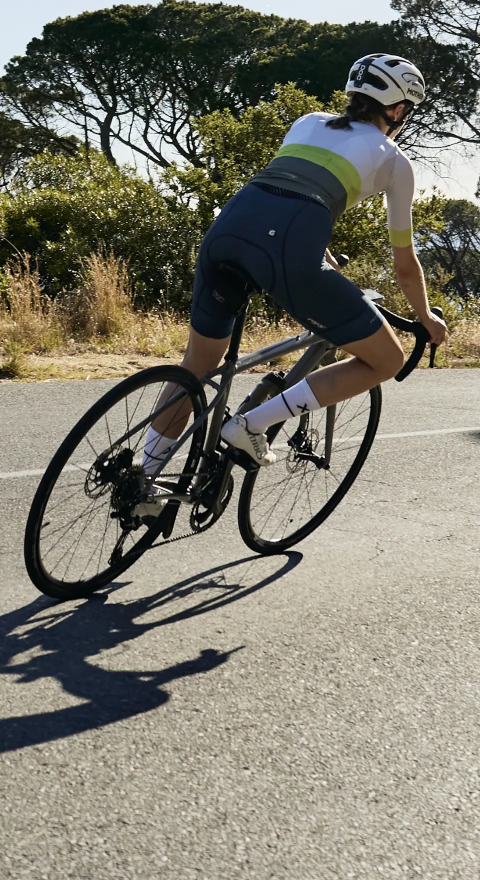 Back view of female cyclist on bike wearing cycling apparel made by enjoy.cc