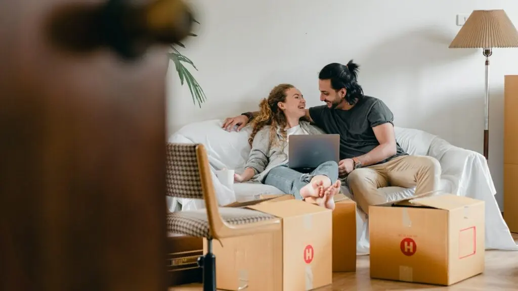 couple on couch surrounded by moving boxes