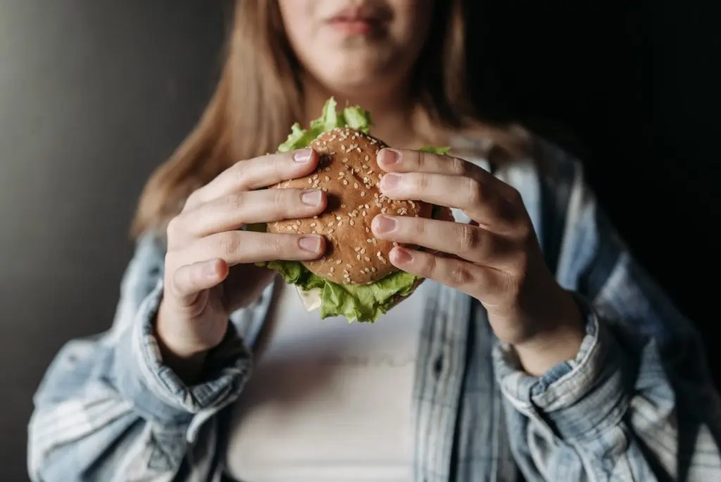 close up of a burger held by a woman