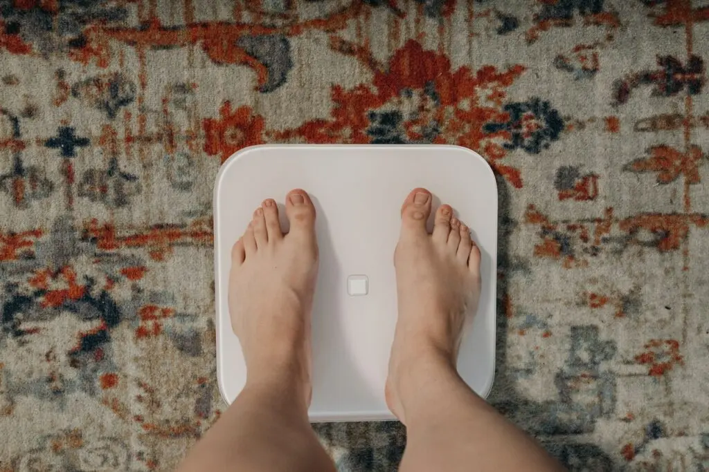 person on weighing scale, trying to lose weight