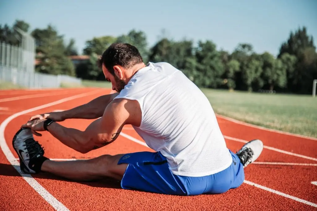 runner stretching on the track