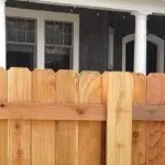 Custom cedar wood privacy fence installation in front of a residential home, ideal for backyard security and home curb appeal.