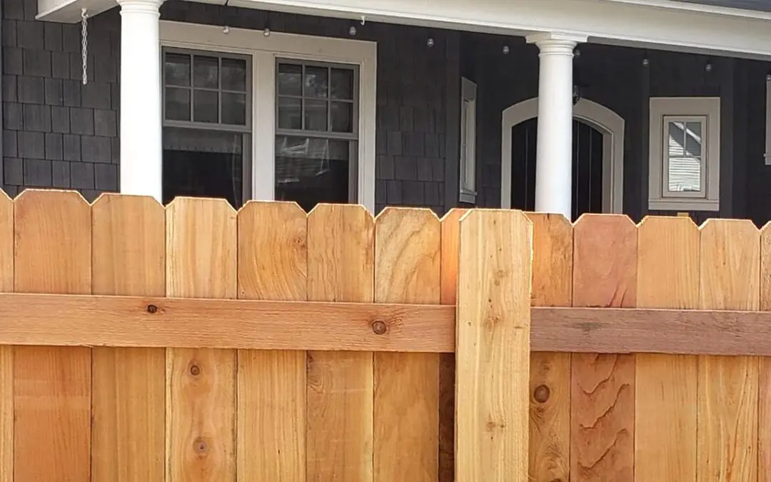 Custom cedar wood privacy fence installation in front of a residential home, ideal for backyard security and home curb appeal.