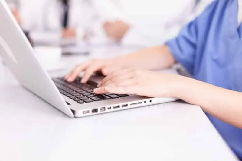 Get Group Uniforms At Scrubs Of Evans 9 Close up of medical nurse typing on laptop