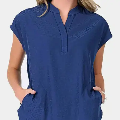 A woman with her hands in her pockets wearing ava therese scrubs from scrubs of evans