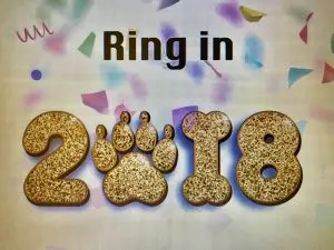 Decorative "Ring in 2018" image featuring gold glitter numbers and a paw print in place of the zero.