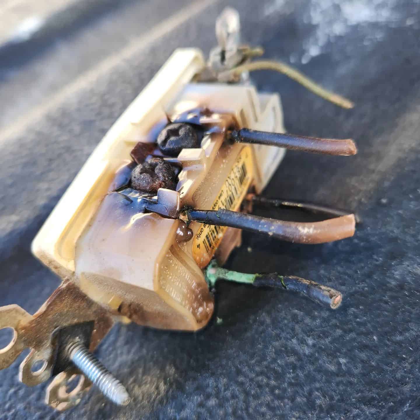Burnt electrical outlet laying on table