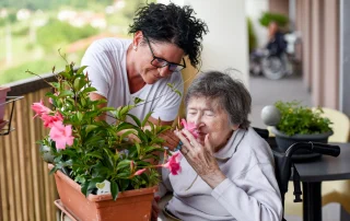 Caregiver assisting a resident with gardening in a residential assisted living home