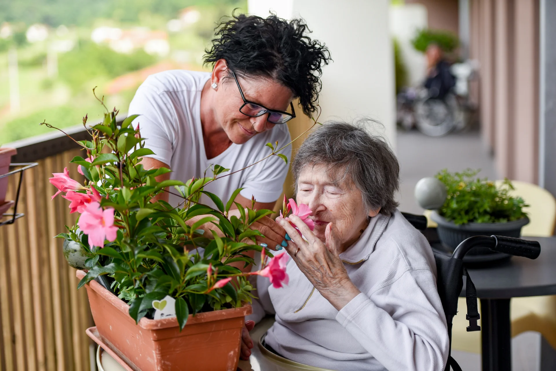 Caregiver assisting a resident with gardening in a residential assisted living home