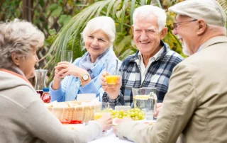 Older adults enjoying a meal and conversation together in a luxury assisted living community