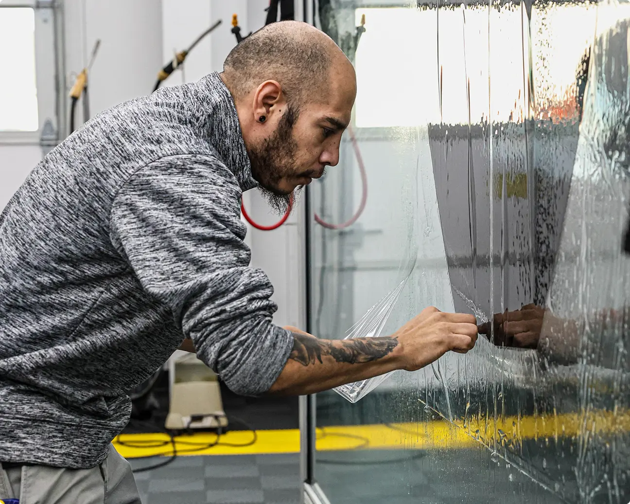 Automotive window tint installer working on a vehicle