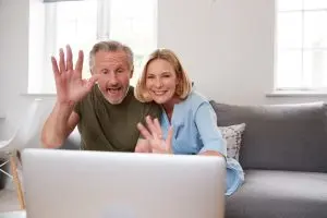 5 Ways to Stay Connected During Social Distancing 1 Senior Couple Sitting On Sofa At Home Making Video Call Using Laptop Computer Together"
