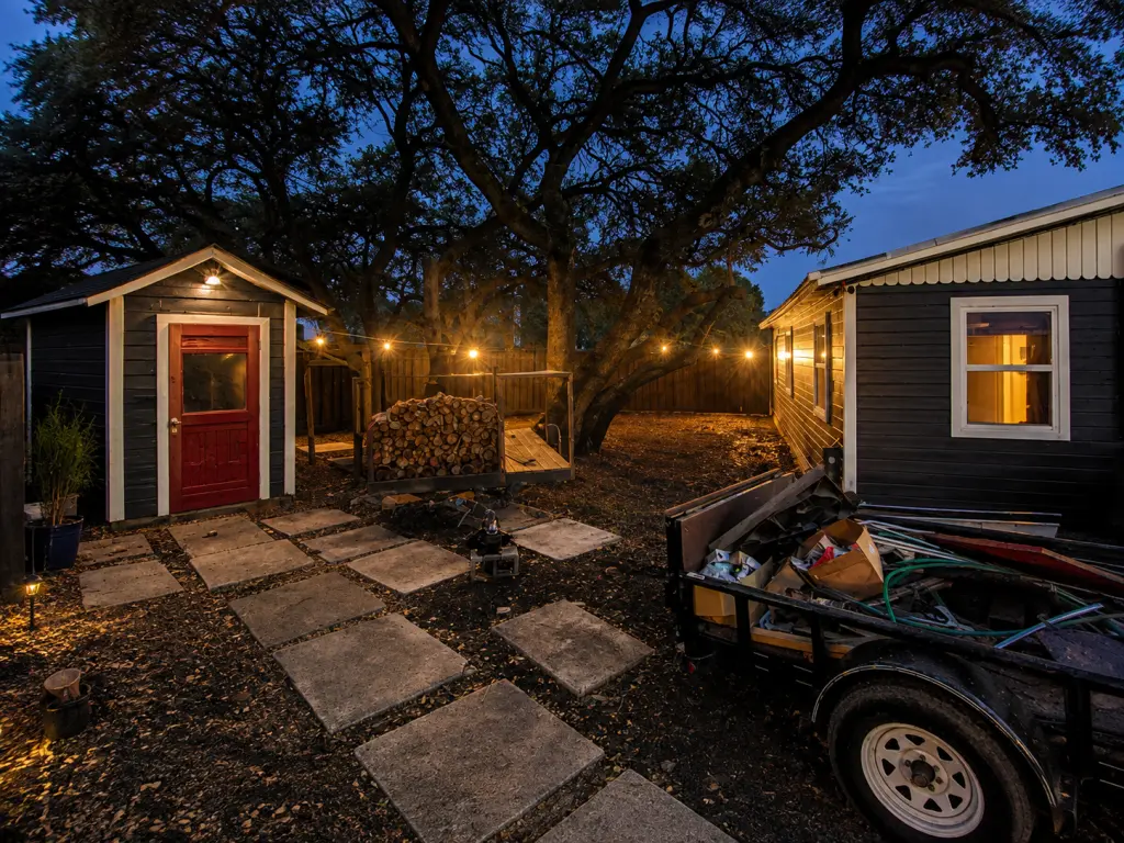 Custom security lighting illuminates a residential backyard, shed entrance, pathway, mature oak tree, and surrounding property.