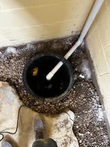 Interior waterproofing techniques using a sump pump basin and PVC drainage pipe in a basement