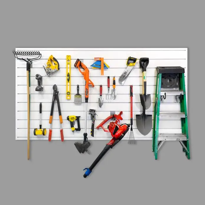 White garage slatwall storage system organized with tools, shovels, and a ladder for contractors.