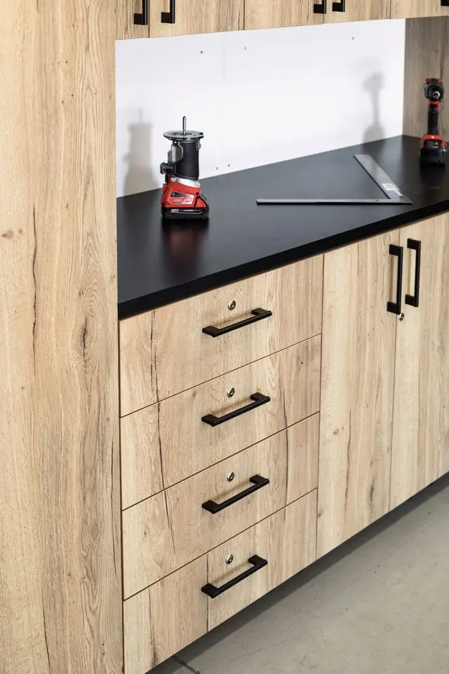 Custom wood-grain garage cabinets with black hardware and countertops installed by Higgins Distribution in Wichita