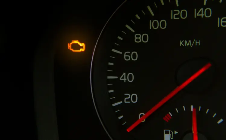 Vehicle dashboard cluster showing illuminated check engine and oil pressure warning lights