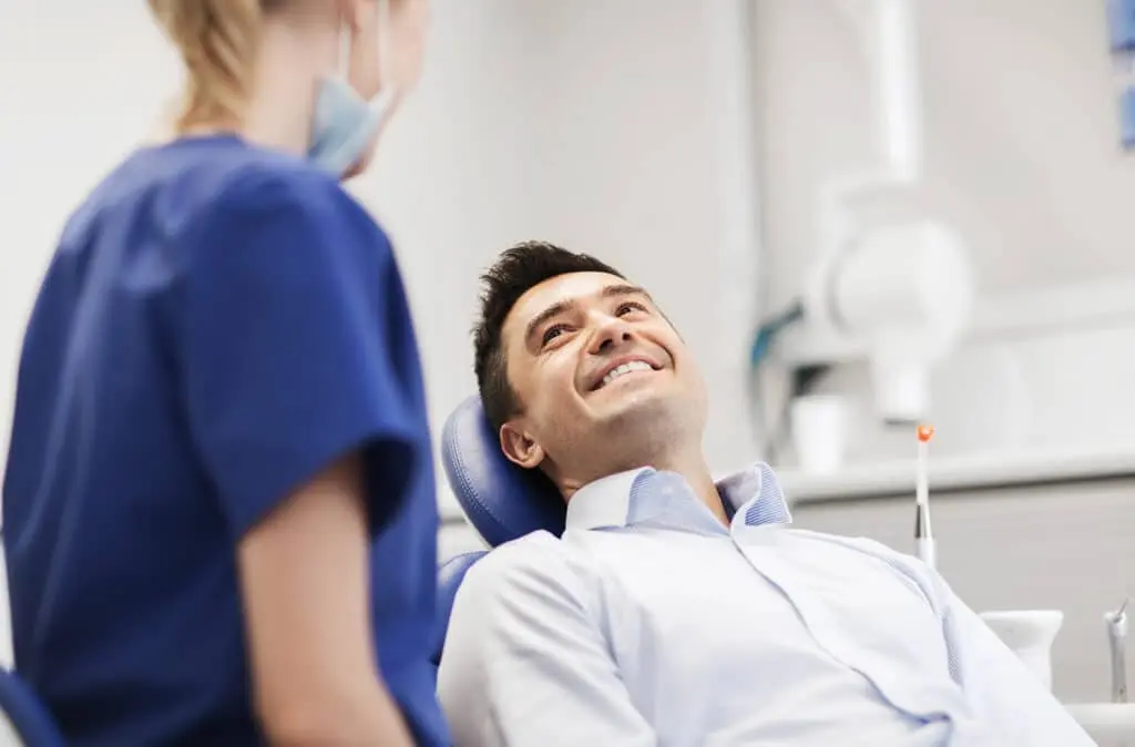 man.smiling.dental.chair