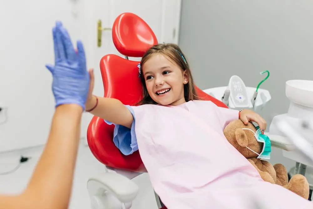 Little girl at the pediatric dentist, smiling, showing the importance of pediatric dentistry in Midland, MI