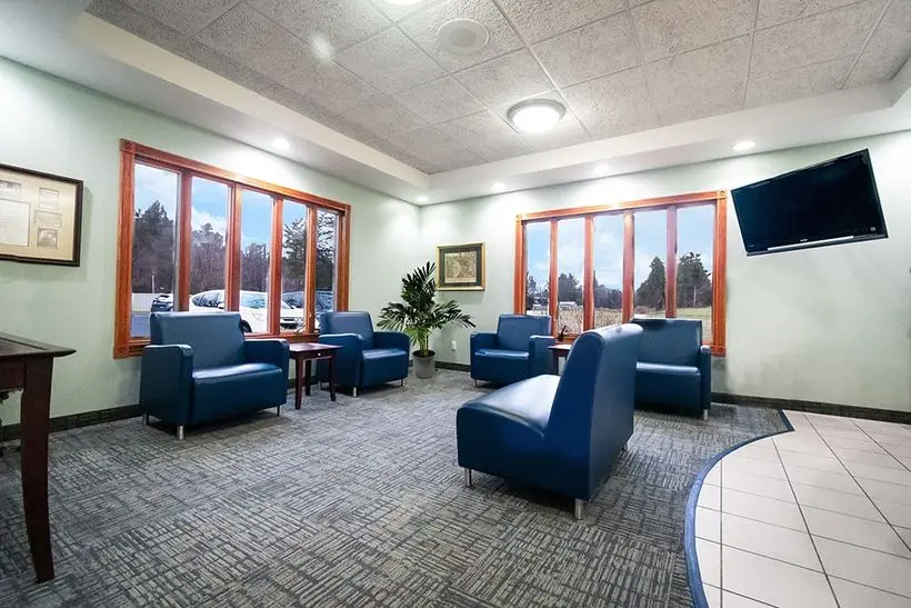 Bright and spacious dental waiting room with blue chairs and large windows at Knight Dental Care in Midland, MI