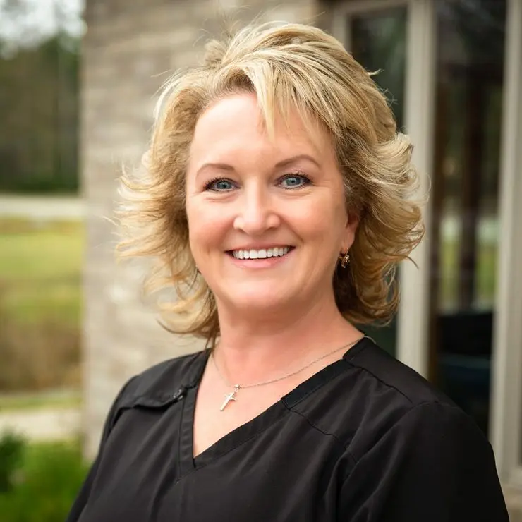 Blonde female dental team member wearing a black top smiling outdoors near Knight Dental Care in Midland, MI