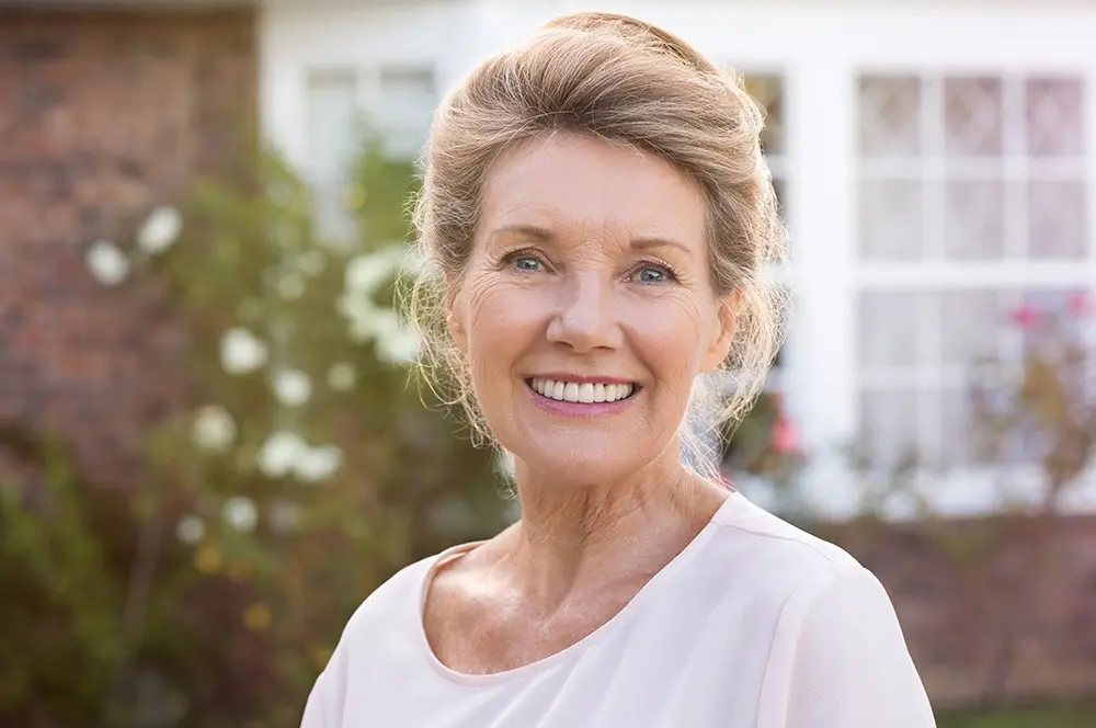 Woman smiling after getting dental implants in Midland, MI