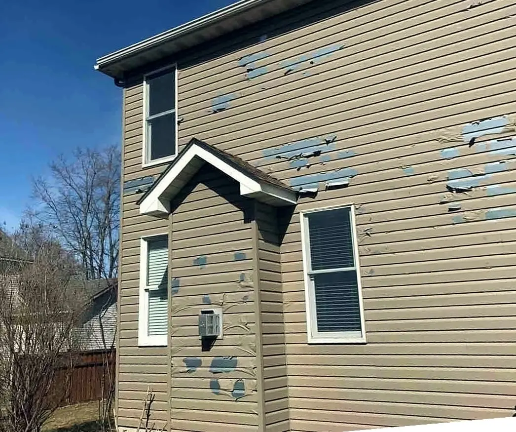 A house featuring a broken window and damaged siding, highlighting the need for siding repair services
