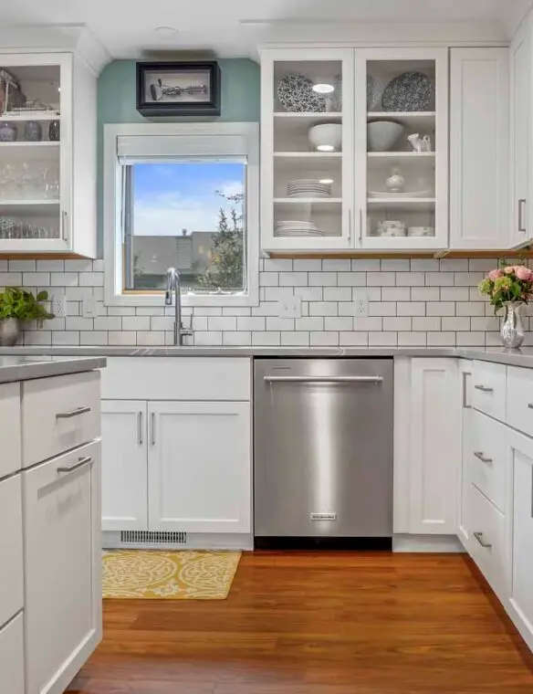 A modern kitchen featuring stainless steel appliances and sleek white cabinets.