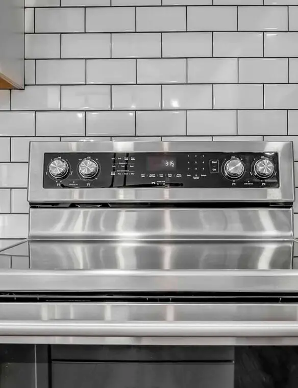 A stainless steel stove top oven installed in a modern kitchen setting.