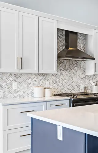 A stylish kitchen with sleek white cabinets and a vibrant blue island as the focal point