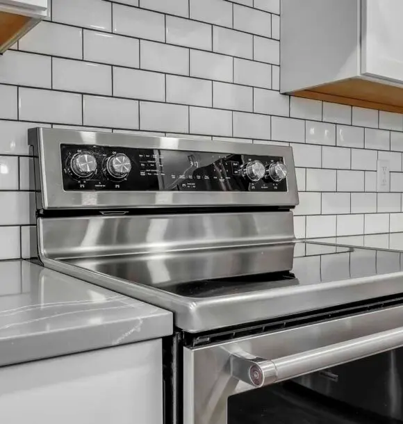 A stainless steel stove top oven installed in a modern kitchen setting.