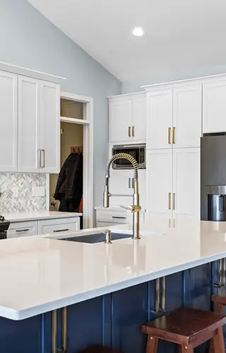 A modern kitchen featuring a white countertop and blue cabinets, creating a bright and inviting atmosphere.