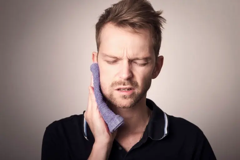 TMJ Exercises for Jaw Pain Relief 2 Man holding jaw in pain due to TMJ disorder.