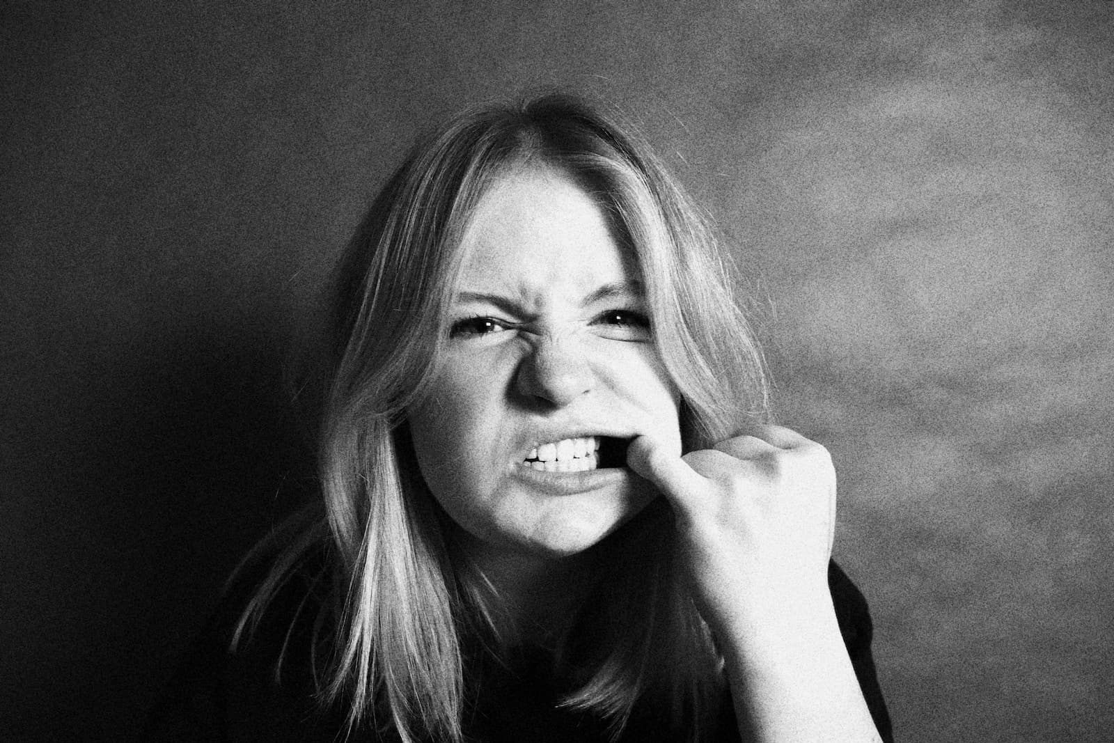 Black and white photo of woman flossing teeth.