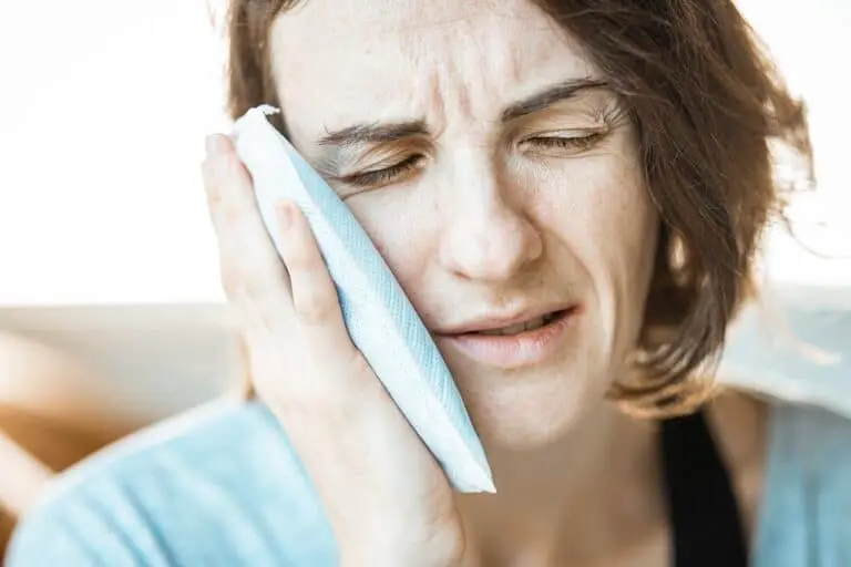 Emergency Root Canal 4 Woman holding ice pack to jaw, showing pain or swelling.